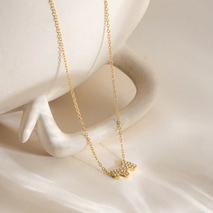 Gros plan du collier avec pendentif chien doré et cristaux brillants sur fond satiné