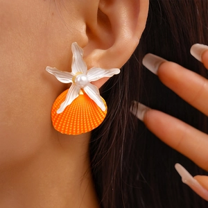 Detail showing orange shell and white starfish earring with pearl on model's ear