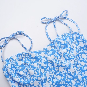 Close-up of thin tie-up straps and blue floral pattern on the summer dress neckline