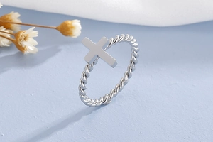 Detailed macro view of the silver cross ring featuring a unique twisted rope band design