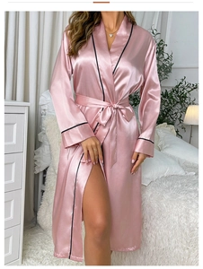 Close-up of pink satin bathrobe featuring elegant black trim and a waist tie belt