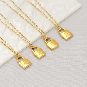 Close-up of golden padlock necklaces with engraved uppercase A, B, C, and D letters