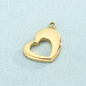 Vue macro d'un pendentif cœur creux en titane doré sur une surface texturée bleue