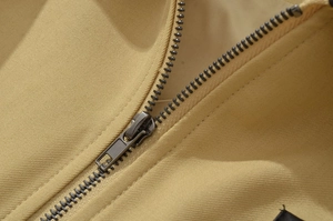 Macro shot of high-quality metal zipper and twill fabric texture on khaki jacket