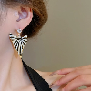 Détail de boucles d'oreilles vintage en éventail avec émail noir et blanc et cristaux