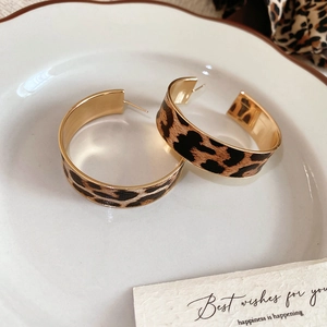 Detail of leopard print vintage leather hoop earrings with golden inner plating