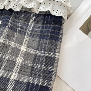 Macro view of blue plaid wool tote bag with white eyelet lace trim and textile texture