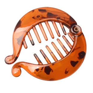 Close-up of tortoise shell banana clip showing inner fine teeth and durable metal rivet