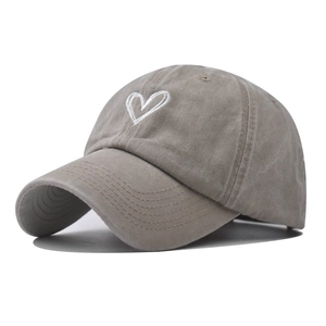Detailed view of white heart embroidery on washed cotton vintage baseball cap texture