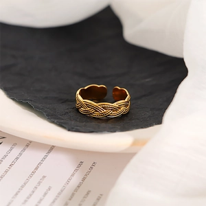 Macro detail of gold plated stainless steel ring with vintage braided rope texture