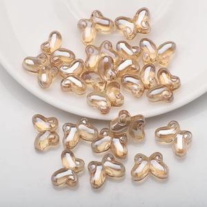 Macro shot of champagne gold butterfly glass beads for DIY jewelry making and crafts