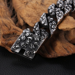 Détail macro du bracelet punk argenté à crâne avec des textures métalliques gaufrées