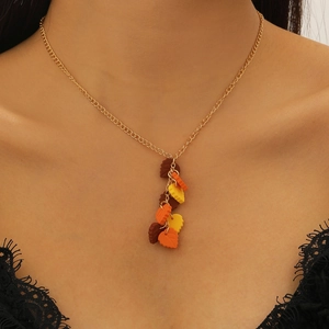 Dettaglio della collana con ciondolo a foglia d'acero e charms in resina arancione e marrone