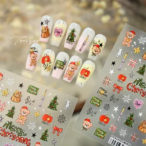 Close-up of Christmas nail stickers with cute bears, trees and festive patterns