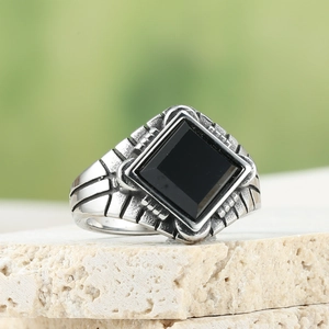 Vintage men's stainless steel ring with square black stone on textured stone base