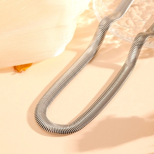 Elegant silver stainless steel flat snake chain necklace on silk background