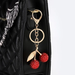 Sac à main en cuir matelassé noir avec breloque cerise scintillante et foulard en soie