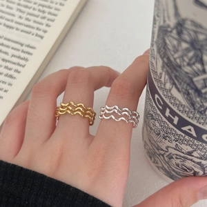 Close-up of minimalist S925 sterling silver wavy stacked rings in gold and silver finish