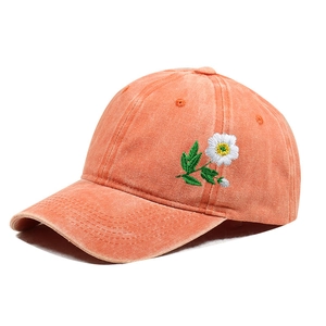 Detail of white daisy embroidery on vintage washed orange cotton baseball cap
