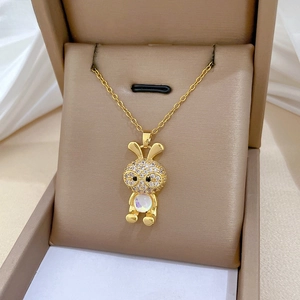 Detailed macro view of a gold bunny pendant with sparkling cubic zirconia and moonstone