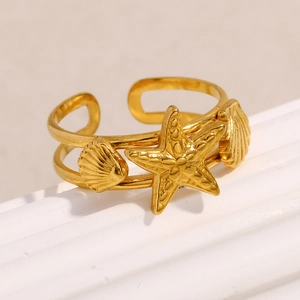 Macro shot of gold-plated starfish and scallop open ring details with dual-layer bands