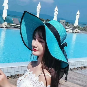 Summer wide brim straw hat in vibrant turquoise with black bow detail for sun protection
