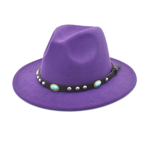 Détail d'un chapeau fedora violet avec bande en cuir noir, perles turquoise et rivets