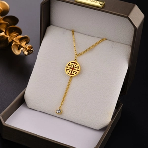 18K gold plated titanium steel necklace with a hollow round pendant and a clear gemstone