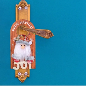 Detail of wooden Christmas door hanger with Santa figure and Feliz Navidad joy greeting