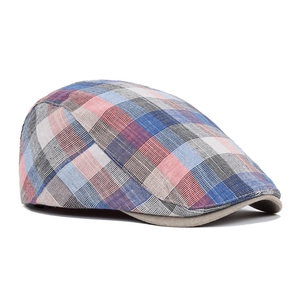 Detail of red and blue checkered cotton flat cap showing fine stitching and fabric texture