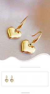 Detail of 14k gold plated heart drop earrings featuring vacuum plated titanium steel hooks