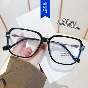 Detail of hand holding black and gold anti-blue light glasses with UV400 protection