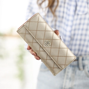 Champagne gold quilted long wallet for women with crown buckle held by model
