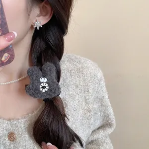 Cute grey plush bear hair clip for women with cartoon eyes on a side hair braid