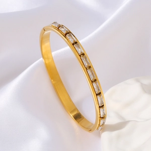 18k gold plated bangle featuring rectangular zircon on elegant satin and plaster background