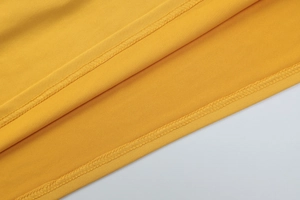 Detailed close-up showing precision double-needle stitching on the yellow dress fabric hem