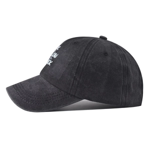Close-up of vintage washed gray cotton baseball cap featuring detailed white embroidery
