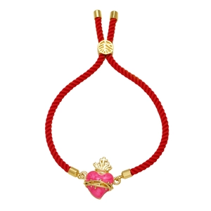 Dettaglio del bracciale in corda rossa con ciondolo cuore smaltato rosa e corona dorata