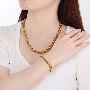 Set collana e bracciale dorati con trama a cesto indossato da un modello pro
