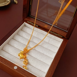 Detail of gold plated pony coin pendant necklace inside a wooden jewelry box