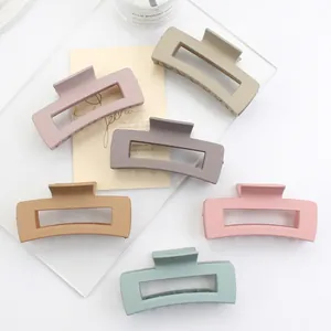 Set of 6 matte rectangular hair claws in various pastel colors on a white minimalist desk