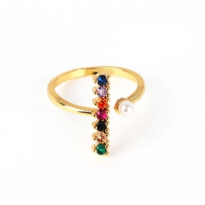Detail of adjustable gold ring featuring seven colorful gemstones and a white pearl