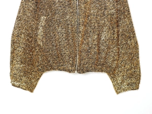 Detailed close-up of metallic gold textured fabric and zipper on bomber jacket