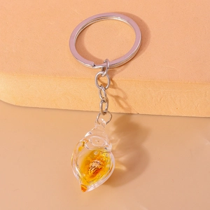 Close-up of a creative glow-in-the-dark conch shell keychain with resin pendant