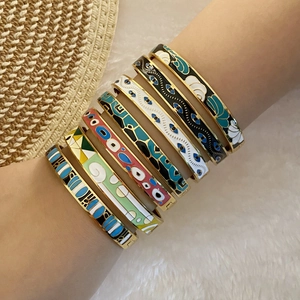 Close-up of colorful enamel evil eye bracelets layered on a wrist for a trendy look