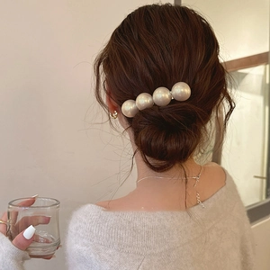 Detail of four large pearls hair clip styled in a Korean low bun hairstyle for women