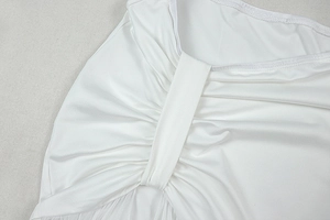 Detailed close-up of white ruched fabric texture and fine stitching on high-stretch dress