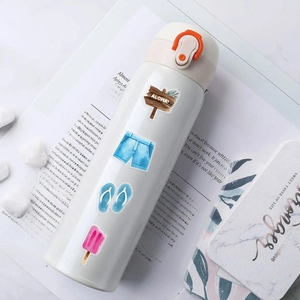 Detail of white water bottle with summer theme stickers on marble and stone background