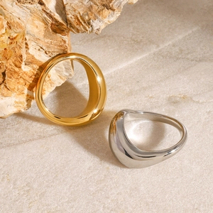 Dettaglio di anelli spessi stile metallo liquido in oro e argento su marmo