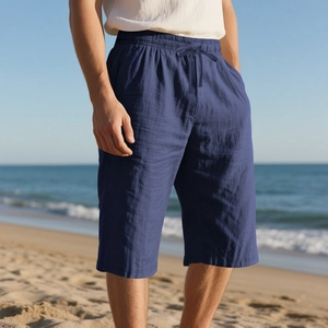 Outdoor shot of men's dark blue linen shorts with drawstring waist on a sunny beach